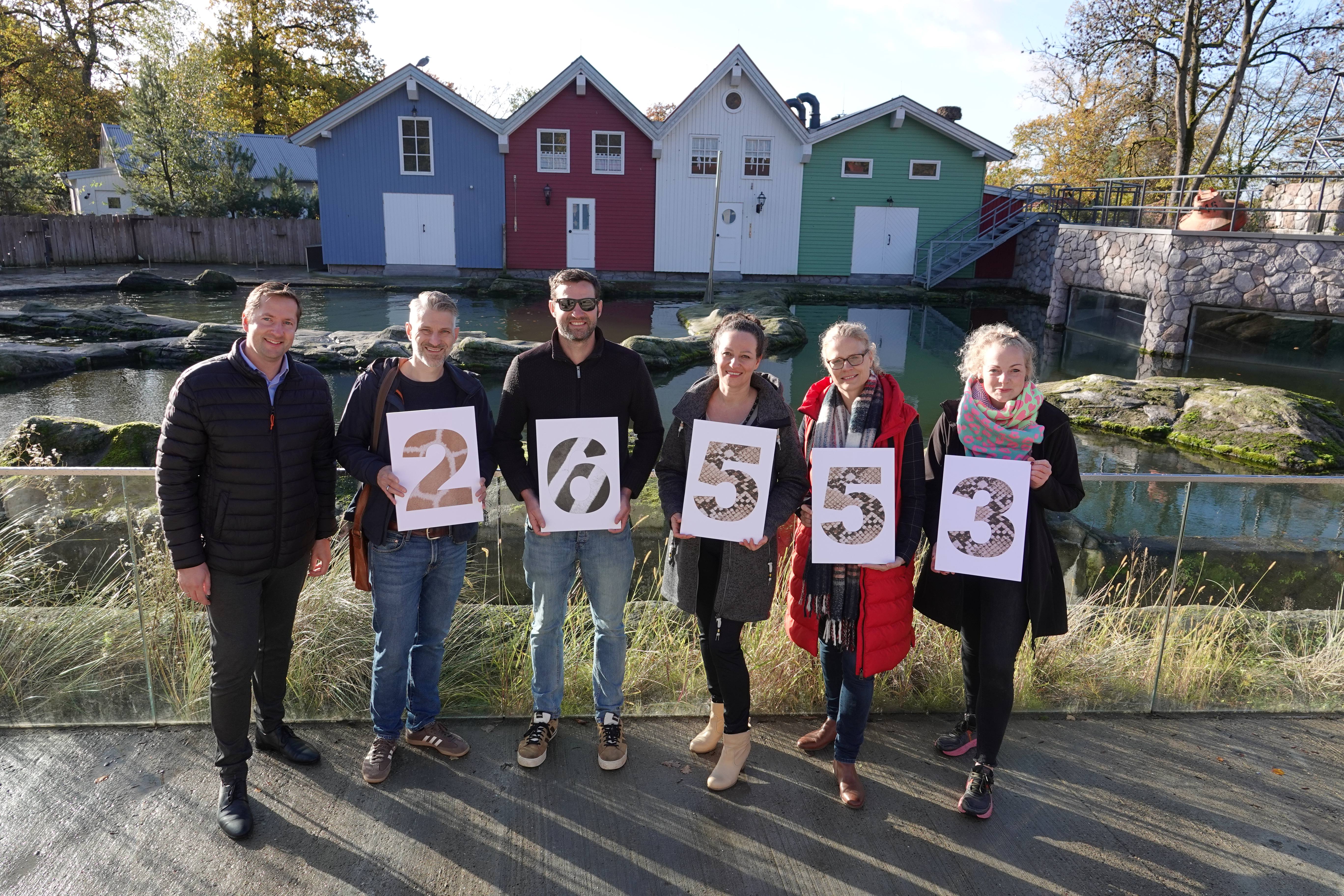 Philipp Bruelheide (Zoo Osnabrück), Hendrik Vogelpohl (TSO-DATA), Philipp Vogelsang (laufen-os.de), Ekaterina Menke (AOK Niedersachsen), Heike Beitz (Sportler 4 a childrens world) und Jennifer Ludwig (Zoo Osnabrück) freuen sich über das Ergebnis des 11. Zoo-Charity-Laufes und halten gedruckte Buchstaben mit der Spendensumme von 26000 Euro